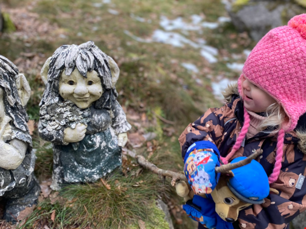 Flicka hälsar på två stentroll.