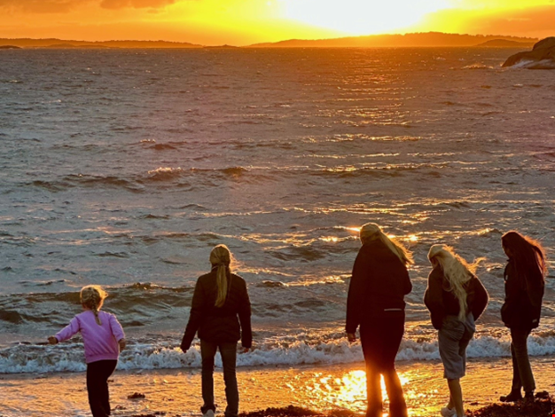 Syskon i solnedgången på stranden.